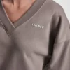Jersey de cuello en V con logotipo metálico en relieve Jersey de cuello en V con logotipo metálico en relieve
