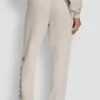 Pantalones jogger de talle alto con logo universitario de pedrería en relieve con corte holgado Pantalones jogger de talle alto con logo universitario de pedrería en relieve con corte holgado