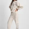 Pantalones jogger de talle alto con logo universitario de pedrería en relieve con corte holgado Pantalones jogger de talle alto con logo universitario de pedrería en relieve con corte holgado